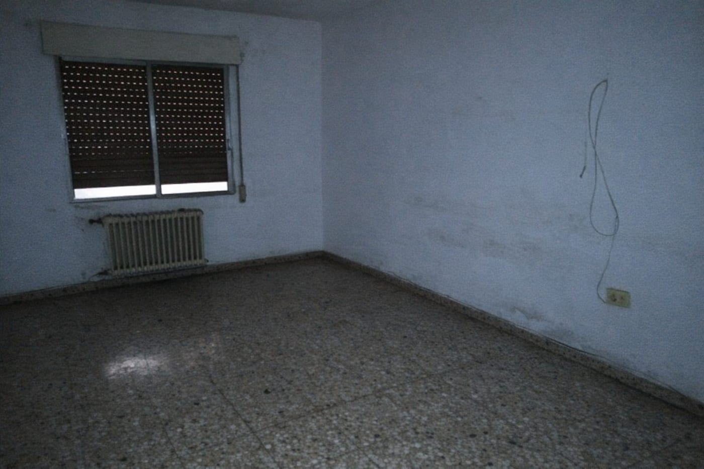 Salón vacío y oscuro, foto original del anuncio
